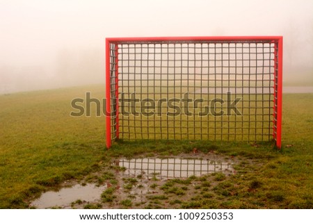 Soccer football gate on a rainy foggy morning with a wet spot in the front