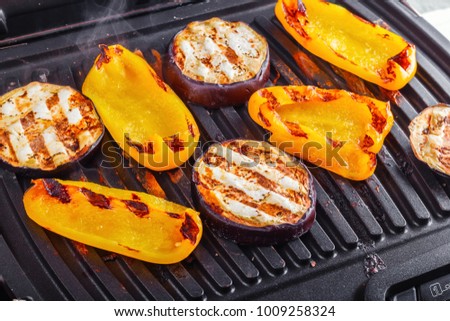 Vegetables: aubergines and yellow pepper on an electric grill. Close-up. Healthy Eating Royalty-Free Stock Photo #1009258324