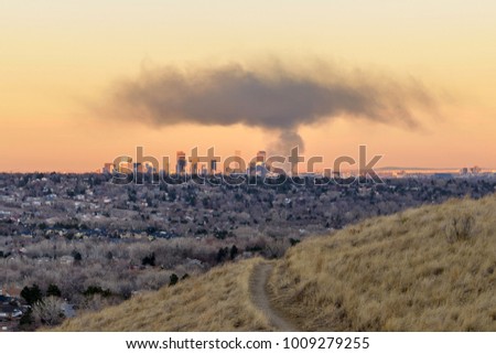 Smoke Cloud Hovering Over Downtown Denver - A thick cloud of black smoke, from a fire at a recycling plant in Denver, hovering over the city's evening skyline, seen from a hilltop in Lakewood. CO, USA