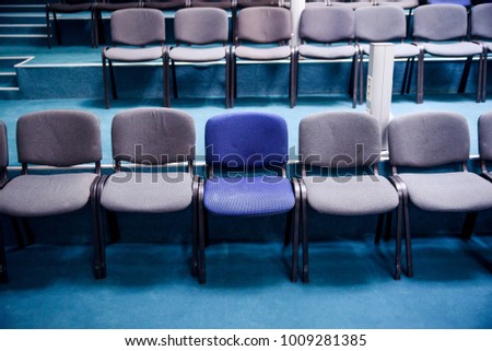 Many comfortable chairs in empty conference hall. Selective focus. Different from others.