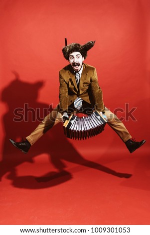 positive man with accordion posing in studio