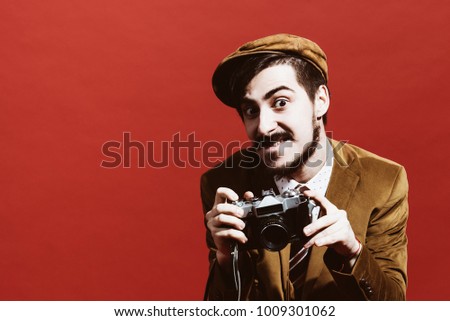very positive photographer posing in studio with camera