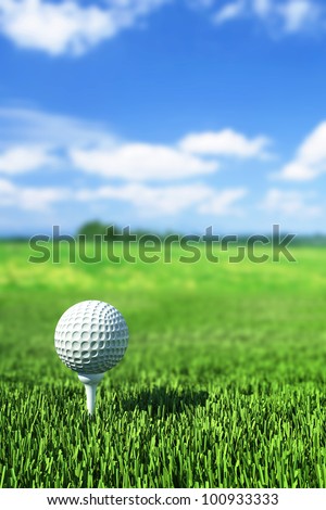 golf ball on tee on the  green grass