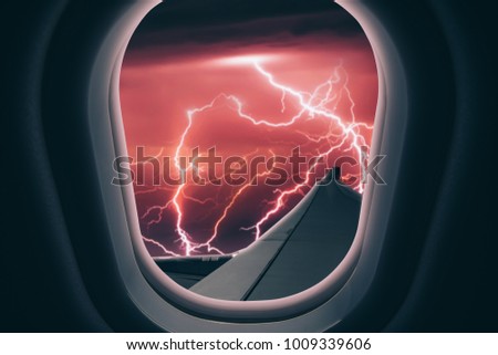 Airplane is flying into the thunderstorm. Dangerous flight at night. View from plane window