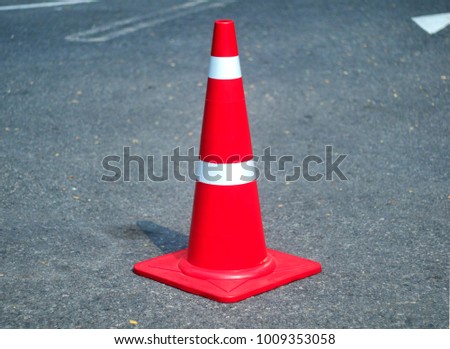 traffic cone,red rubber cone,reflective strips,road surface