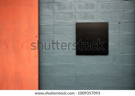 Blank black signboard on grey bricks wall. Loft industrial style decoration. Composition with copy space.