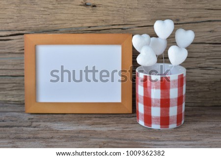 Heart shape flower in red Scottish vase with blur wooden frame on vintage wooden background
