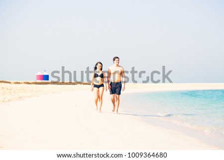 Tourists Walking On The Beach