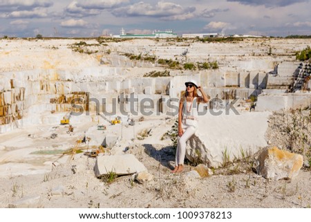 the girl sits on a large piece of marble