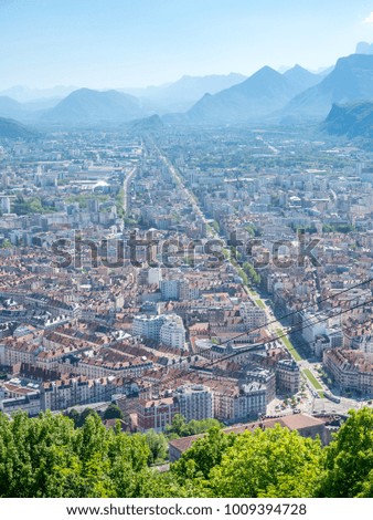 Cityscape view of Grenoble city, from Basille hill and fortress in France, under cloud sky