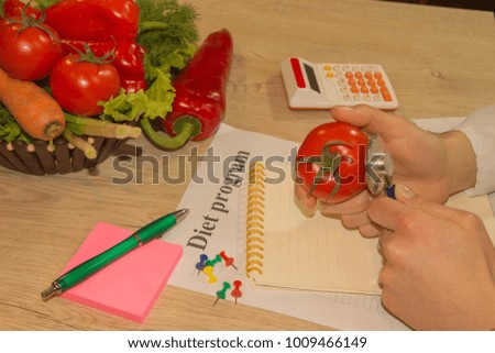 Young female nutritionist working in her office. Dietitian nutritionist checking examine a tomato with stethoscope