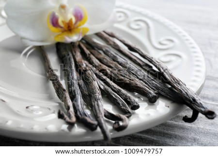 Plate with vanilla sticks and flower, closeup