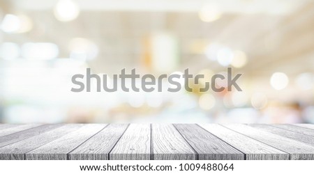 wooden tabletop under image of blurred bokeh light at supermarket