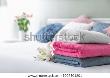 Stack of clean towels on bed Royalty-Free Stock Photo #1009501201