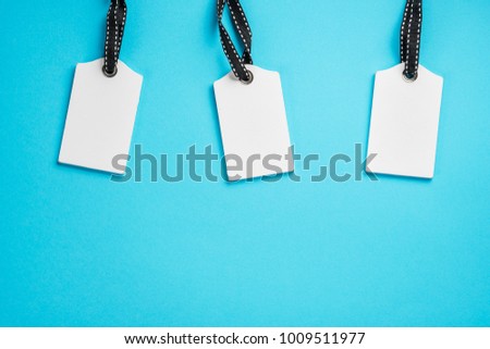 Empty white tags in a row on blue background. Top view. Mock up sample. Blank price tag. Design for shopping label template, discount, Sale. Sales tags.