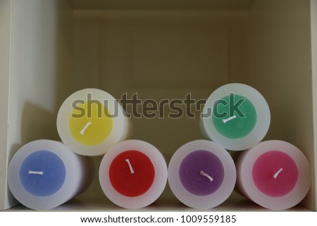 Close up view of colorful circular wick candles. Geometric and modern design. Pattern with circular sufaces of different bright colors. Abstract colored picture of decorative indoor objects. 