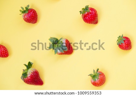 Top view of colorful fruit pattern of fresh strawberries on yellow background