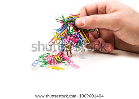 man hand holding magnet attracting metal paper clips