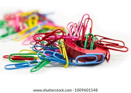 Magnet covered by paper clips isolated on a white background