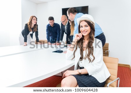 Woman architect working on blueprints in office