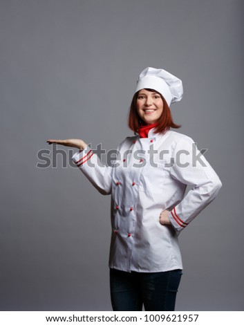 Image of smiling brunette chef in white robe with empty palm