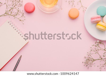 Morning cup of coffee, cake macaron, gift or present box and flower on light table from above. Beautiful breakfast. Flat lay style.