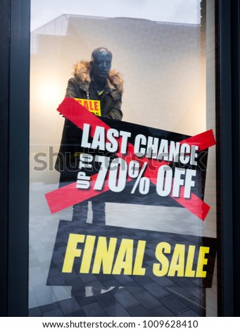 big letters indicate sale in shop windows of clothing store