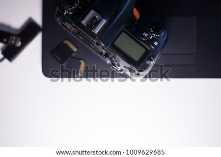 Digital camera with  memory card on laptop preparing to transfer photos