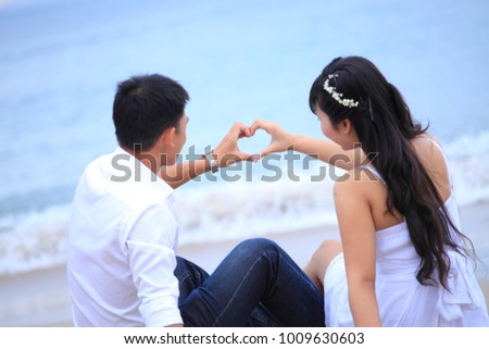 Romantic love Asia couple with wedding dress on the beach. Royalty high-quality free stock image of romantic love couple hands holding making heart shape with hands. Romance young asia couple wedding 