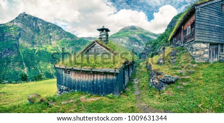 Norwegian typical grass roof wooden old house near Seven Sister waterfall. Colorful summer panarama of Norway, Europe. Beauty of countryside concept background. Instagram filter toned.