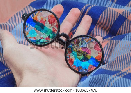Designer glasses with lenses of a kaleidoscope lie on the hand
