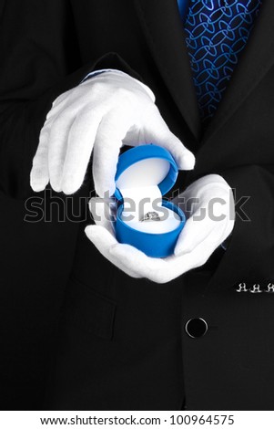 Man's hands holding ring in box