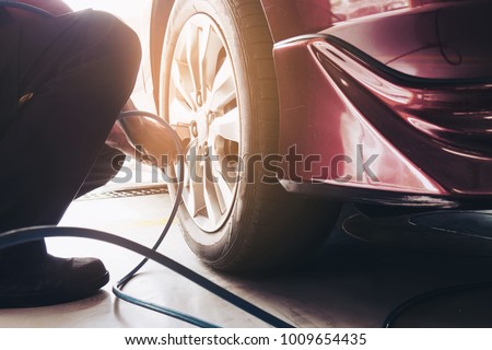 Technician is inflate car tire - car maintenance service transportation safety concept Royalty-Free Stock Photo #1009654435