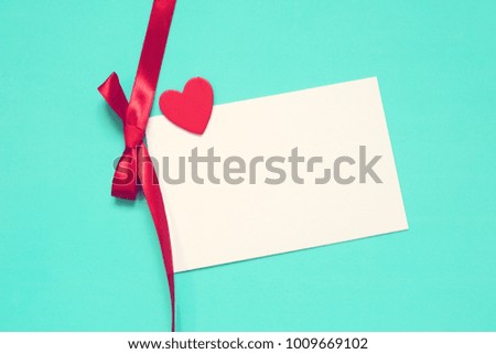 card, heart and red ribbon. Turquoise background. Wedding card