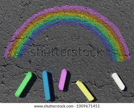 Colorful children's crayons on the asphalt close up