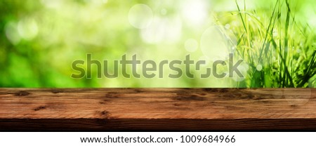 Green spring background with empty old wooden table for a easter decoration
