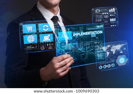 Business, Technology, Internet and network concept. Young businessman working on a virtual screen of the future and sees the inscription: Implementation