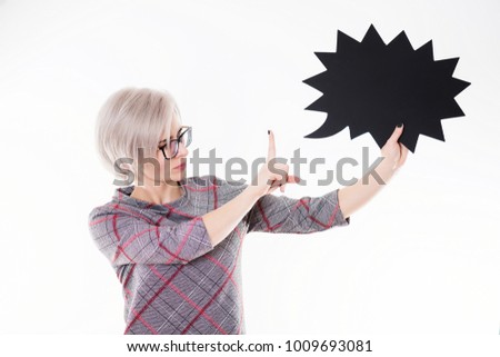 Young beautiful emotional blonde woman in black glasses holding chalkboard on white background