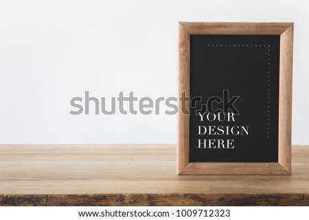 blackboard in frame with text your design here on white  Royalty-Free Stock Photo #1009712323