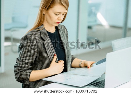 Picture of TV anchor preparing for telling news while sitting in modern office interior.