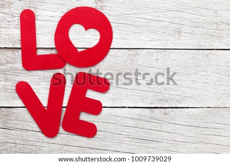 Valentines day greeting card with love word over wooden background. With space for your greetings