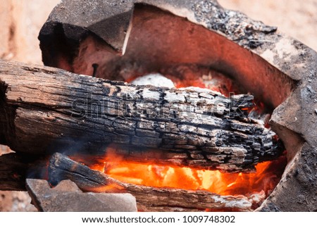 Wood burning charcoal in old stove to warm the body in winter., thailand tradition
