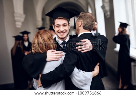 Parents congratulate the student, who finish their studies at the university. He graduates. They are very happy about this. Royalty-Free Stock Photo #1009751866