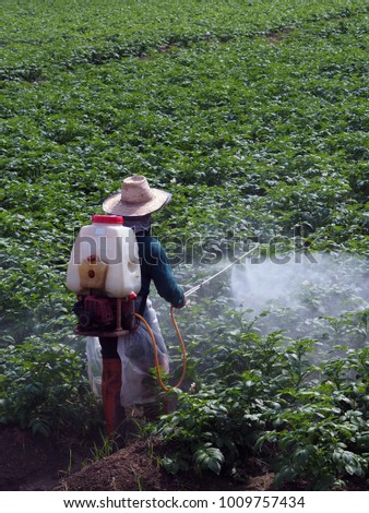 Farmers are spraying chemicals on the farm. Royalty-Free Stock Photo #1009757434