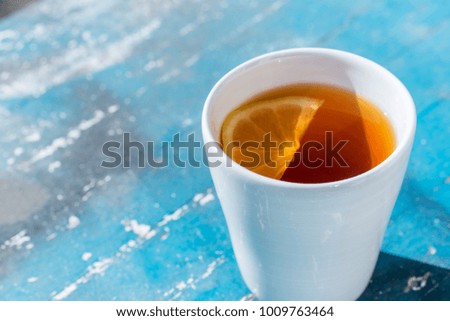 Close up white cup with tea and lemon