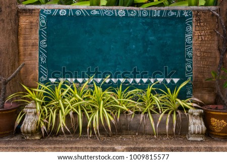 a concrete blue wall with a frame of  seaside sun vacation pictures of a spiral fish in the style of Hawaii Tropics with yellow green plants underneath and a great place for text. Leisure at sea