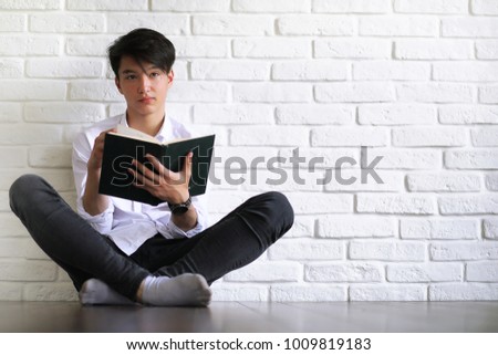 asian young man student with books in hands