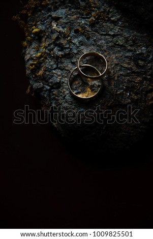 Two wedding rings on wooden background. Low key still life photography