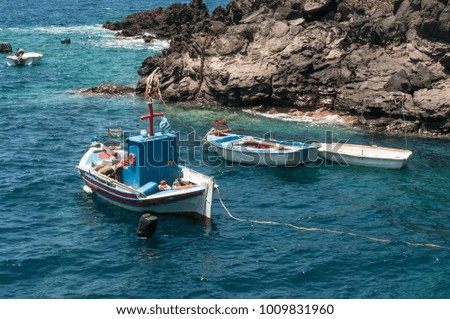 Small fishing boats from local fishermen anchored by the coast in Santorini Island, Greece 
