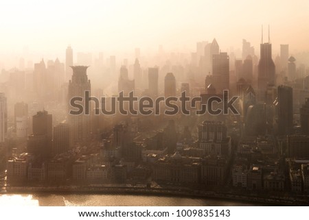Smog lies over the skyline of Historical architecture and modern skyscraper on the bund of Shanghai city in misty sunrise, Shanghai, China vintage picture style